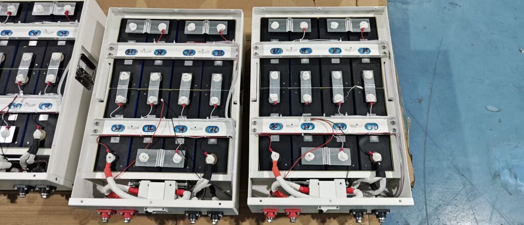 Rack-mounted 51.2V LiFePO4 battery modules installed in an energy storage cabinet next to a hybrid inverter