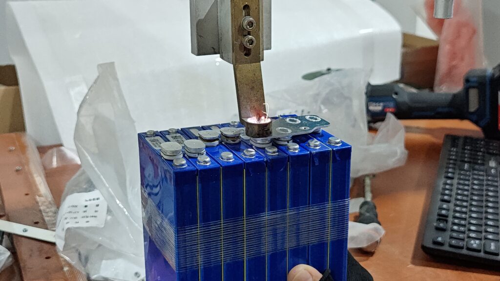 Assembled lithium battery packs connected to a charge-discharge test cabinet during factory capacity testing  